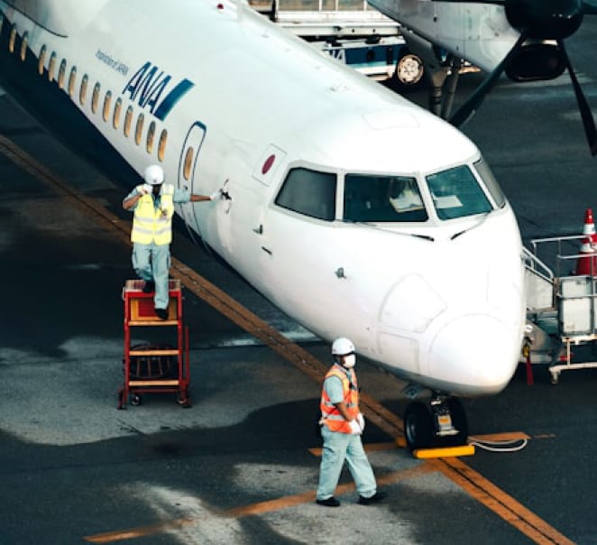 Ground crew servicing an aircraft inside a maintenance hangar